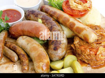 Verschiedene Arten von gegrillten Würstchen mit verschiedenen Saucen Stockfoto