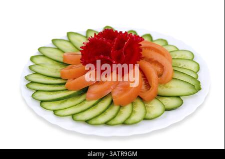 In Scheiben geschnittene frische Gurken und Tomaten mit einer Rote-Bete-Blüte oben, Schnittpfade, isoliert auf weiß Stockfoto
