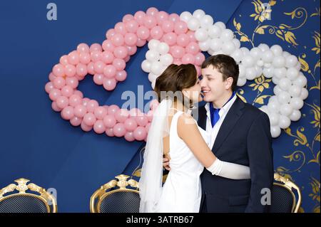 Ein Bräutigam umarmt seine Braut vor dem Hochzeitsbankett Stockfoto