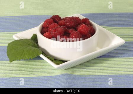 Fresh raspberries with leaves in a bowl Stockfoto