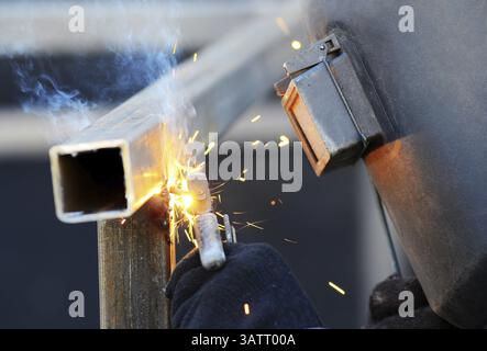 Ein Schweißer in einer Schutzmaske schweißt Stockfoto