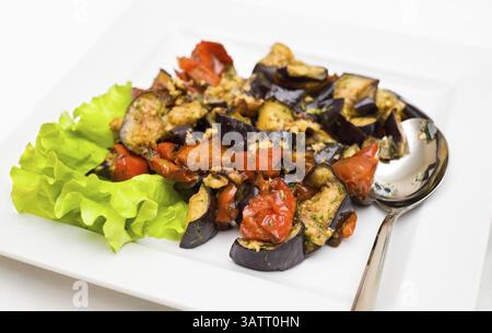Gedünstetes Gemüse – Auberginen und Tomaten, serviert mit Salat Stockfoto