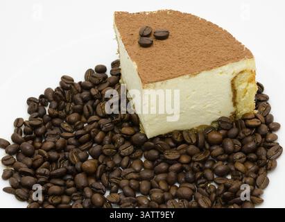 Ein Stück Tiramisu unter Kaffeebohnen Stockfoto