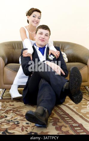 Ein Bräutigam und seine Braut schauen glücklich in die Kamera Stockfoto