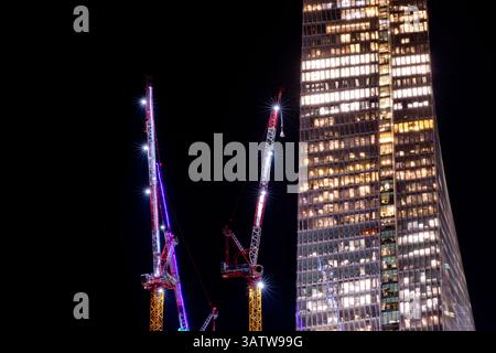 Unter einem tiefen Himmel erstrahlt der Azrieli Sarona Tower in Tel Aviv-Jaffa, Israel, mit gemusterten Fenstern und Kränen, die städtische Innovationen hervorheben. Ein wahres Wunder. Stockfoto