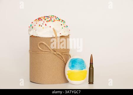 Die Flagge der Ukraine ist auf dem Ei gezeichnet, daneben eine Kugel und ein Osterkuchen, Ostern in der Ukraine im Krieg Stockfoto