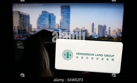 Deutschland. März 2025. Auf dieser Abbildung befindet sich ein Mobiltelefon mit dem Logo der Firma Henderson Land Development Co. Ltd. Auf dem Bildschirm vor der Webseite. (Foto von Timon Schneider/SOPA Images/SIPA USA) *** ausschließlich für redaktionelle Nachrichten *** Credit: SIPA USA/Alamy Live News Stockfoto