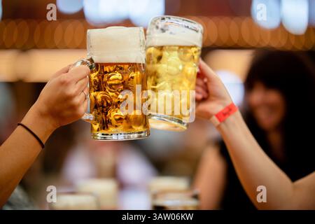 Stuttgart, Deutschland. April 2025. Die Besucher der 85. Stuttgarter Frühlingsfestspiele erheben ein Glas Bier in einem Festzelt. Das 85. Stuttgarter Frühlingsfest findet vom 19. April bis 11. Mai 2025 im Cannstatter Wasen statt. Quelle: Christoph Schmidt/dpa/Alamy Live News Stockfoto