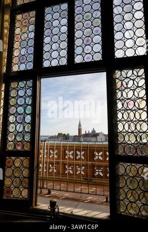 Die Kirche San Giorgio Maggiore auf der Insel San Maggiore in der Lagune aus dem verzierten Fenster im Dogenpalast, San Marco, Venedig Stockfoto
