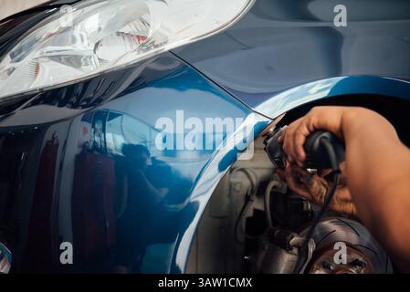 Bangkok, Thailand - 13. Januar 2018 : ein unbekannter Automechaniker oder Servicemitarbeiter überprüft und repariert Karosserieteil für neue Autoschürze in der Autogarage oder Stockfoto