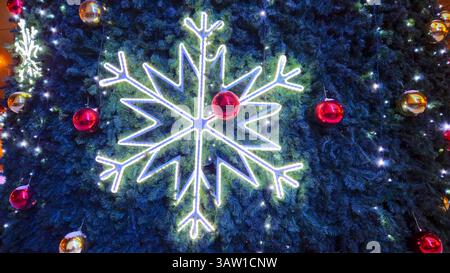 Große glühende Schneeflocke und Glaskugeln auf dem Weihnachtsbaum, helle und schöne Neujahrs- und Weihnachtsdekorationen, Feiertagshintergrund Stockfoto