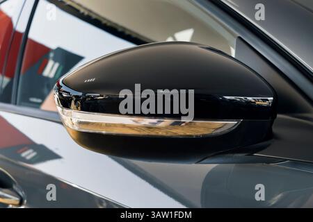 Seitenspiegel eines modernen Autos mit glänzend schwarzer Oberfläche und integriertem Blinker. Stockfoto