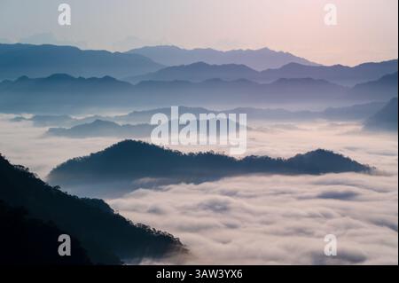 Eine ruhige Morgenszene mit nebelbedeckten Bergen in Xindian, Taiwan, kurz vor Sonnenaufgang. Dieses Bild fängt die ruhige Schönheit der Natur ein Stockfoto