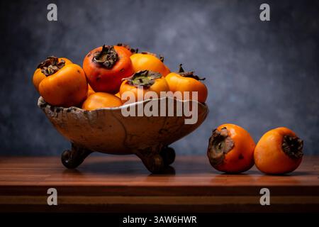 Eine Persimmonplatte mit gemaltem Hintergrund Stockfoto