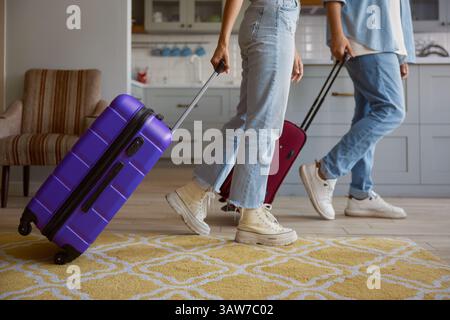 Bildausschnitt von Paaren, die das Haus verlassen, mit Gepäck für den Urlaub bereit Stockfoto
