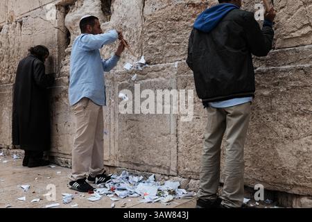 12. April 2016 – Jerusalem, Israel – Mitarbeiter der Westmauer und der Heiligen Stätten verwenden Holzspitzen, um kleine gefaltete Gebetsnotizen von den Spalten der Westmauer am Vorabend des jüdischen Passahs zu entfernen. Die Notizen werden zweimal im Jahr gelöscht und auf dem jüdischen Friedhof auf dem Ölberg feiert. (Bild: © Nir Alon via ZUMA Wire) Stockfoto