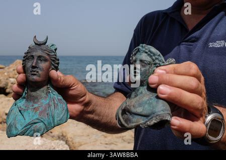 16. Mai 2016: Cäsarea, Israel – JACOB SHARVIT, Direktor der Marine Archaeology Unit der Israel Antiquities Authority, hält Figuren der Mondgöttin Luna (links) und Dionysos (rechts), dem Gott des Weines, in die Höhe. Eine in den letzten Wochen von Tauchern der Israel Antiquities Authority durchgeführte Unterwasser-Bergungsuntersuchung im alten Caesarea Harbor hat dazu geführt, dass ein â œlarge, ein spektakuläres und schönes, antikes Marineschiff cargoâ eines Handelsschiffs, das während der späten römischen Zeit vor etwa 1.600 Jahren sank, ausgesetzt war. Unter den gut erhaltenen Bronzeartefakten befinden sich zwei metallische Klumpen, die aus Th bestehen Stockfoto
