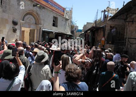 Rückansicht einer Menge katholischer Pilger, die betend und singend in einer Karfreitagsprozession auf der Via Dolorosa in der Altstadt von Jerusalem spazieren gehen. Stockfoto