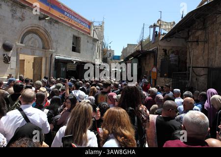 Rückansicht einer Menge katholischer Pilger, die betend und singend in einer Karfreitagsprozession auf der Via Dolorosa in der Altstadt von Jerusalem spazieren gehen. Stockfoto