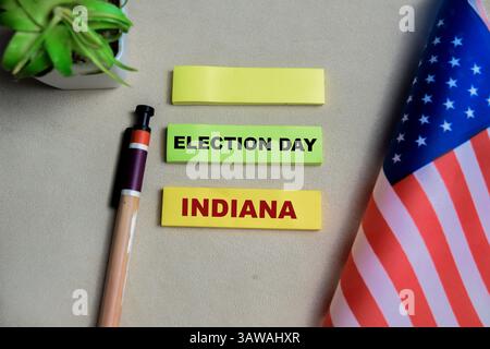 Konzept der Präsidentschaftswahl indiana schreibt auf Haftnotizen und der Flagge, die die vereinigten staaten auf Holztisch isoliert haben. Stockfoto
