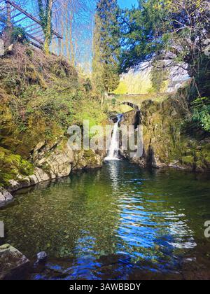 Ein malerischer Blick auf die Rydal Falls im Lake District, Großbritannien. Dieser malerische Ort bietet einen kleinen Wasserfall, der unter einer Steinbrücke fließt. Stockfoto