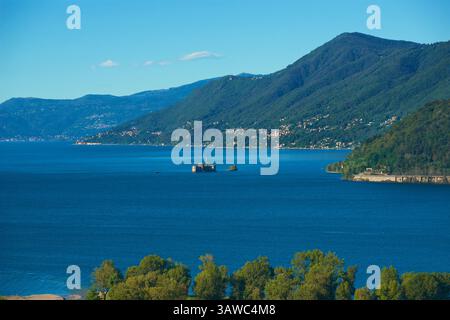 Blick auf den Lago Maggiore vom Aussichtspunkt Belvedere di Campagnano, neben der Kirche San Rocco in Campagnano, Varese, Italien. Die Castelli di Cannero sind drei felsige Inselchen des Lago Maggiore in Nord-Italien. Sie befinden sich vor der Küste der Cannero Riviera und sind administrativ Teil der Comune of Cannobio. Sie sind als castelli oder Burgen bekannt, in Anerkennung der Ruinen der antiken Befestigungsanlagen, die auf zwei von ihnen gefunden werden. Sie sind alles, was von der Festung Rocca Vitaliana übrig geblieben ist, die zwischen 1519 und 1521 erbaut wurde. Stockfoto