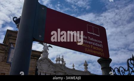 Straßenschild mit der alten Tabakfabrik, heute Universität von Sevilla, in Sevilla, Spanien - SEVILLA, SPANIEN - 25. MÄRZ 2025 Stockfoto