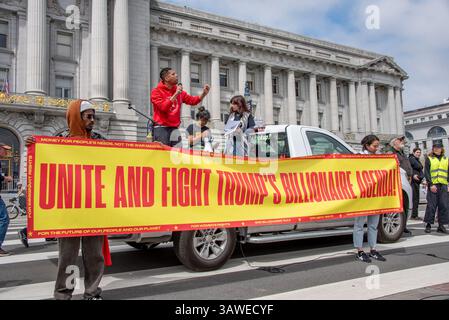 San Francisco, USA. April 2025. Ein leidenschaftlicher Redner spricht die Menge von Demonstranten an, die sich auf dem Civic Center Plaza zum Protest gegen die Trump-Regierung versammelt haben. Vor ihm halten die Demonstranten ein breites Banner für die Veranstaltung mit der Aufschrift „Unite and Fight Trumps Billionaire Agenda!“ Quelle: Shelly Rivoli/Alamy Live News Stockfoto
