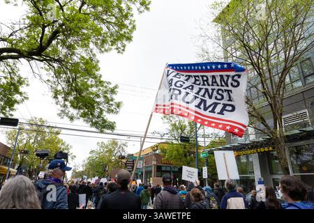 Seattle, Washington, USA. April 2025. Ein Demonstrant hält die Flagge „Veterans Against Trump“, als er am Samstag, den 19. April 2025, in Seattles Stadtteil Capitol Hill entlang der Broadway Ave marschiert. Die Demonstration zur Unterstützung von Demokratie, Vielfalt und Gerechtigkeit ist Teil eines nationalen Aktionstages gegen Aktionen der Trump-Regierung. Quelle: Paul Christian Gordon/Alamy Live News Stockfoto