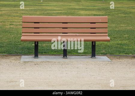 Braune Parkbank in der Nähe von Gras Stockfoto