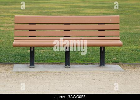 Braune Parkbank in der Nähe von Gras Stockfoto