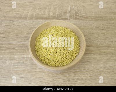 Goldene Hirse in einer Holzschale Stockfoto
