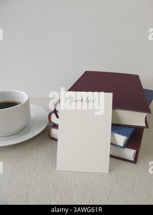 Ein Stapel Bücher, eine Liste mit Büchern und eine Tasse Stockfoto