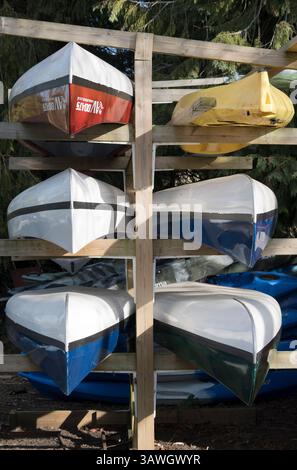 Bunte Kanus stapeln sich auf dem Bootshaus von Nag's Head Island, Abingdon. Abingdon behauptet, die älteste Stadt Englands zu sein. Und die Themse verläuft durch das Herz. Nags Head Island liegt am Fluss und zwischen seinen beiden berühmten alten Brücken. Stockfoto