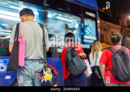 Bangkok, Thailand - 4. Juli 2024: Auf den geschäftigen Straßen der Stadt am frühen Abend stehen Leute an Bushaltestellen und warten darauf, an Bord zu verschiedenen Zielen in der ganzen Stadt zu gehen Stockfoto