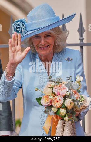 Königin Camilla winkt der Menge zu, als sie ein Pott hält, nachdem sie am Ostermattins-Gottesdienst in der St. George's Chapel in Windsor Castle, Berkshire, teilgenommen hatte. Bilddatum: Sonntag, 20. April 2025. Stockfoto