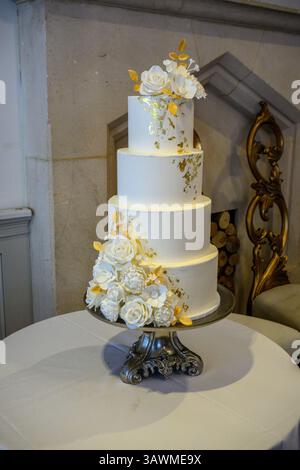 Vierstöckige Hochzeitstorte mit Blattgold und Zuckerblumen Stockfoto