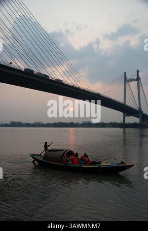 Der Blick auf die Vidyasagar Setu (zweite Hoodly-Brücke) von Prinsep Ghat bei Sonnenuntergang wird tatsächlich als fesselnder Anblick angesehen. Stockfoto