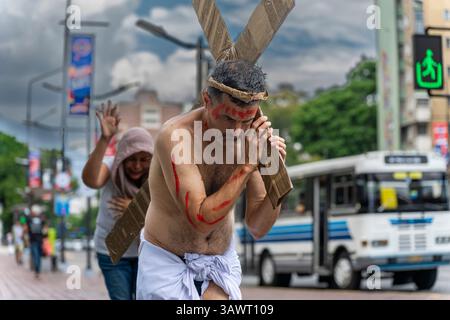 Ein Mann in einer Darstellung Jesu Christi überquert einen Straßenübergang in Caracas. Stockfoto