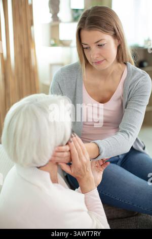 Eine ältere Frau wird von einer erwachsenen Tochter getröstet Stockfoto