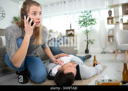 Eine junge Frau, die einen Notfall-Freund mit Schlaganfall anruft Stockfoto