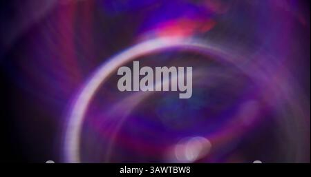 Mehrfarbig blinkt. Scharf schimmerndes, kreisendes Licht. Violette Neonfarbe funkelnde Partikel Bewegung auf dunklem schwarzem, verschwommenem abstraktem Bokeh hheller Hintergrund. Stockfoto
