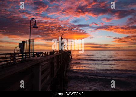 August 2016 - Daytona Beach, Florida, USA S - die Wolken leuchten auf, wenn die Sonne über dem Atlantik auf dem berühmten Daytona Beach Pier aufgeht, während ein Fischer seine Ausrüstung aufstellt. (Kreditbild: © Michael Johnson via ZUMA Wire) Stockfoto
