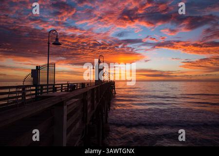 August 2016 - Daytona Beach, Florida, USA S - die Wolken leuchten auf, wenn die Sonne über dem Atlantik auf dem berühmten Daytona Beach Pier aufgeht, während ein Fischer seine Ausrüstung aufstellt. (Kreditbild: © Michael Johnson via ZUMA Wire) Stockfoto