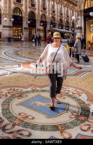 MAILAND, ITALIEN - 23. MAI 2017: Eine Touristin spinnt ihre Fersen auf den Hoden eines Stiermosaiks (Wappen von Turin) in der Galleria Vittorio Emanuele. Stockfoto