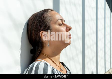 Eine ruhige und selbstbewusste Frau in Kleidung und Schmuck im ethnischen Stil, Nahaufnahme fotografiert Stockfoto