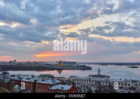 Ein pulsierender Sonnenuntergang über Strelka in Nischni Nowgorod, wo der Fluss Oka auf die Wolga trifft, mit der Alexander Newski Kathedrale und der Wolga Shipping Compan Stockfoto