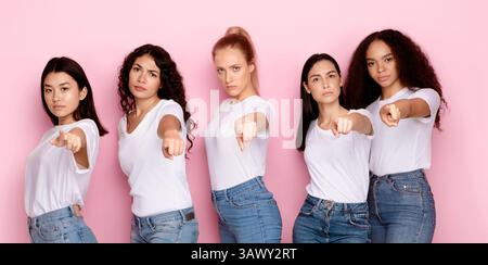 Fünf Ernsthafte Multiethnische Frauen Zeigen Mit Den Fingern Auf Die Kamera, Rosa Hintergrund Stockfoto