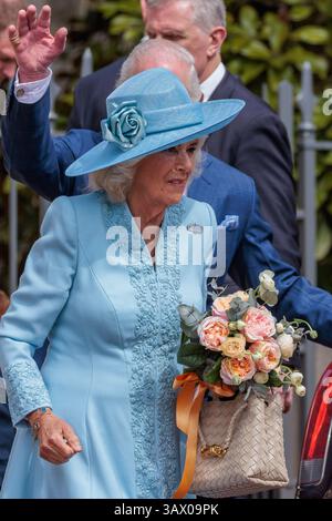 Windsor, Großbritannien. April 2025. König Karl III. Winkt, als er mit Königin Camilla abreist, die ihr von einem jungen Wohlwollenden überreichte Blumen in der Hand hält, nachdem er am Ostersonntag in der St. George's Chapel in Windsor Castle teilgenommen hatte. Der Ostersonntag ist der Mittelpunkt der Osterfeier der Königsfamilie. Quelle: Mark Kerrison/Alamy Live News Stockfoto