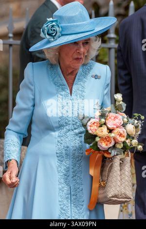 Windsor, Großbritannien. April 2025. Königin Camilla, die ein Blumenstrauß hält, das ihr von einem jungen Wohlwollenden überreicht wurde, reist nach dem Besuch des Gottesdienstes am Ostersonntag in der St. George's Chapel in Windsor Castle ab. Der Ostersonntag ist der Mittelpunkt der Osterfeier der Königsfamilie. Quelle: Mark Kerrison/Alamy Live News Stockfoto